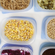 Corn, beans and other foods in separate plastic Tupperware containers